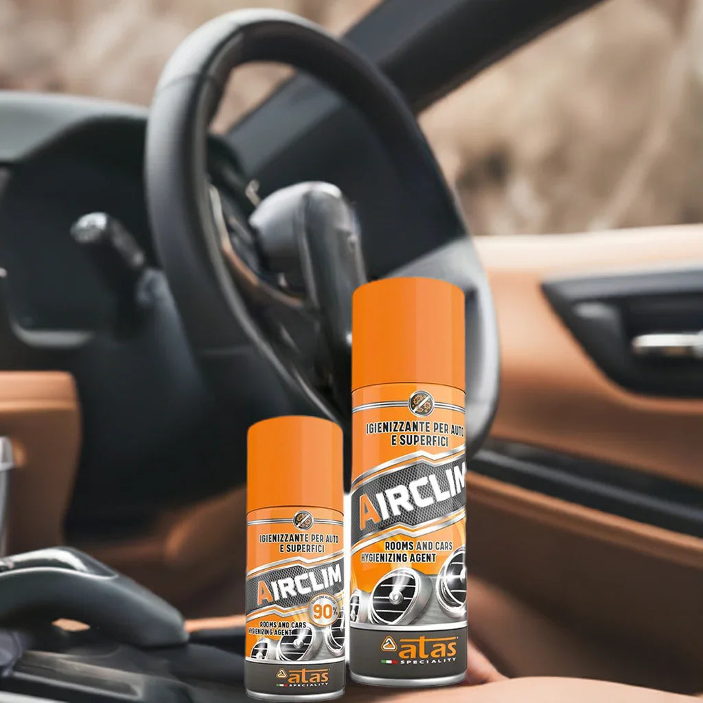Spray igienizzante Airclim per auto e superfici, due flaconi su sfondo abitacolo auto.